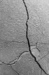 Garden abstract in black and white Closeup of long crack, with tributaries, in the side of a large planter, for concepts of time, pressure, susceptibility, or imperfection