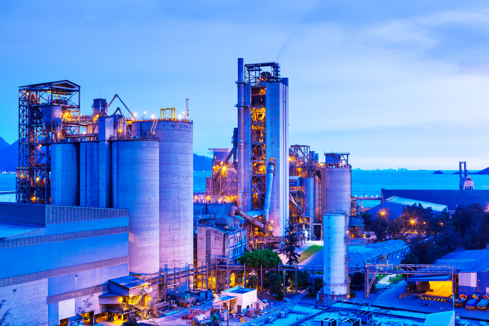 Night view of a pesticide production plant in North Brabant, with illuminated RTO stacks against a starry sky.